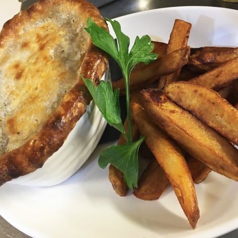 A pie with hand cut chips and salad