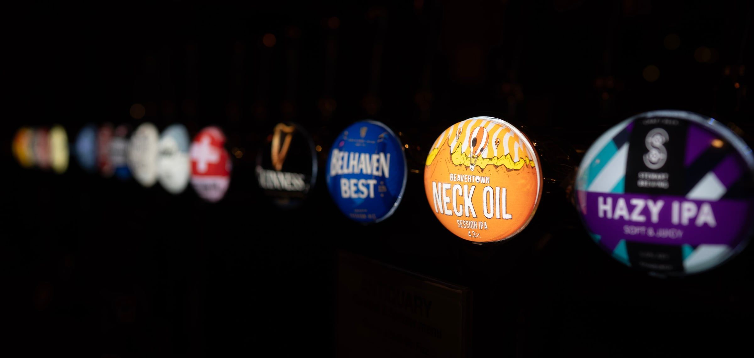 Tap badges along the bar: Guinness, Belhaven Best, Neck Oil and a hazy IPA